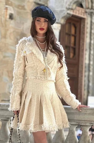 Model wearing beige tweed crop blazer with gold buttons and pleated mini skirt – Brea set by shopUNIQUES